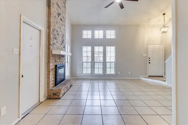 a view of an empty room and window chandelier fan