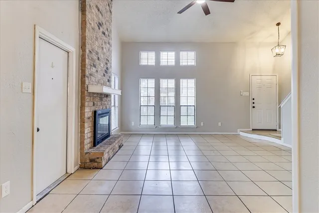 a view of an empty room and window chandelier fan
