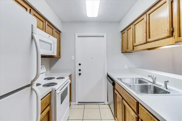 a view of a kitchen with a sink and refrigerator