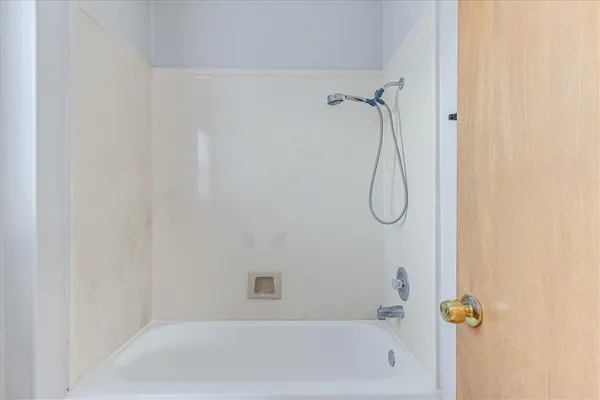 a view of an empty room and chandelier fan
