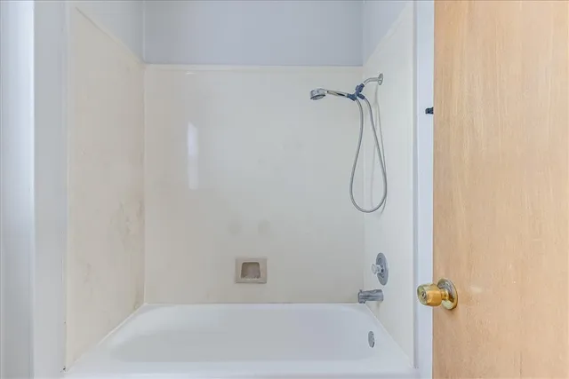 a view of an empty room and chandelier fan