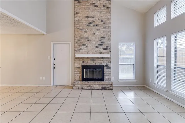 a view of an empty room with window and fireplace