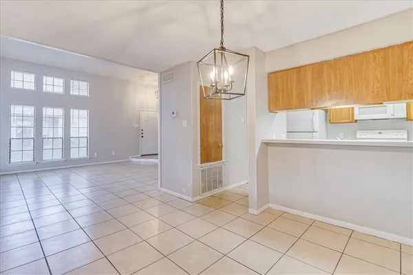 a view of empty room with window and chandelier