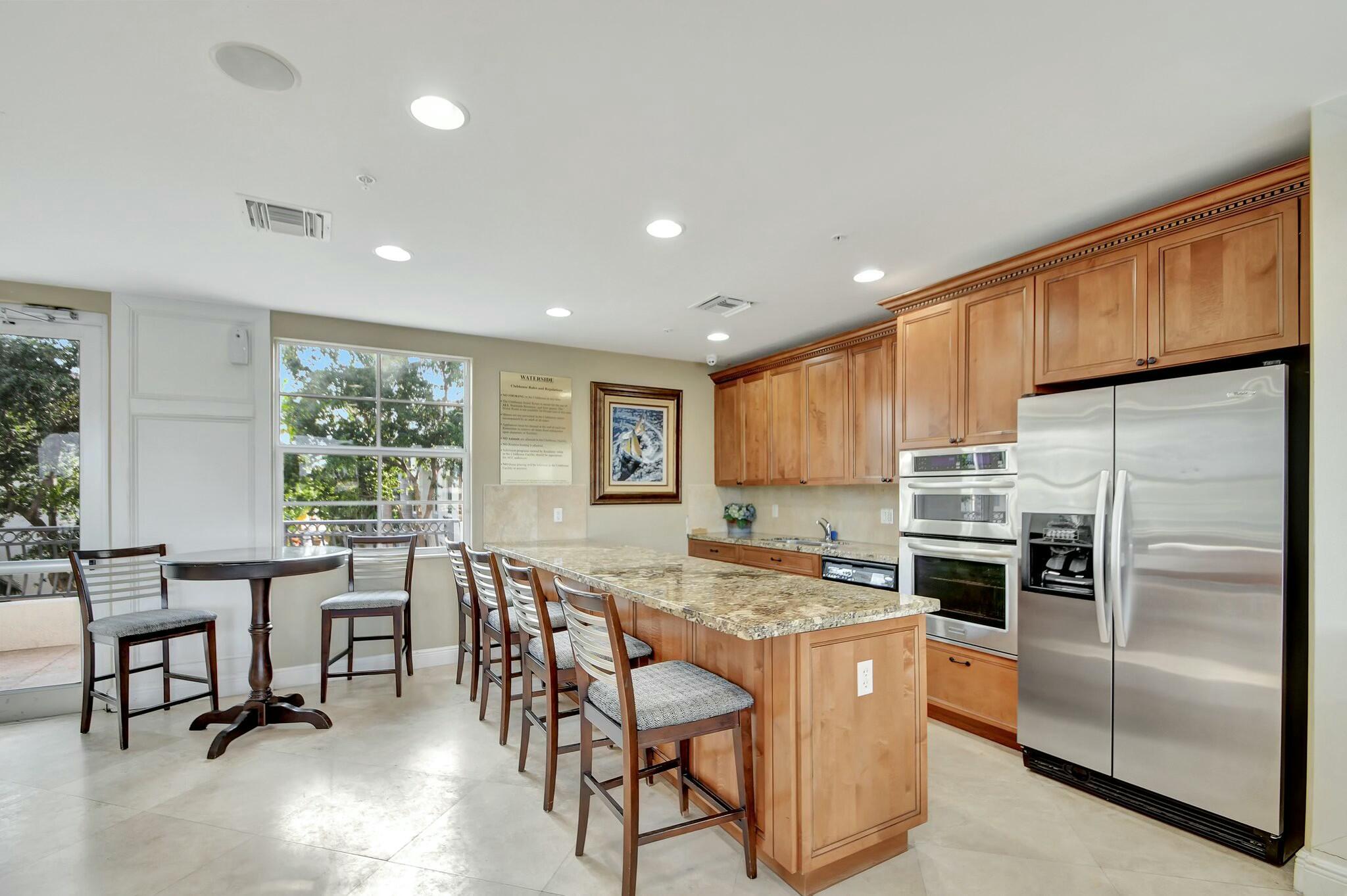 3110 Waterside Circle Boynton Beach, FL 33435 - Photo 40 of 40 a kitchen with stainless steel appliances granite countertop a table chairs sink refrigerator and cabinets