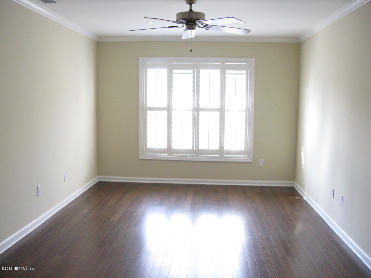 5428 Stanford Road Jacksonville, FL 32207 - Photo 11 of 20 an empty room with wooden floor chandelier fan and windows