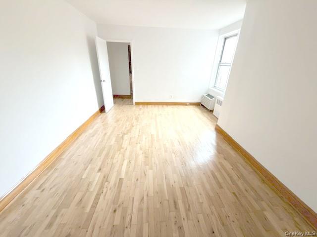 59-30 108th Street, Unit 6J Queens, NY 11368 - Photo 11 of 22 Empty room featuring light wood finished floors and baseboards