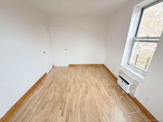59-30 108th Street, Unit 6J Queens, NY 11368 - Photo 8 of 22 Spare room with light wood finished floors and a wall mounted AC