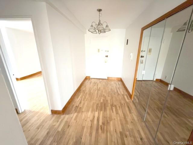 59-30 108th Street, Unit 6J Queens, NY 11368 - Photo 9 of 22 Hall featuring light wood-style flooring and a chandelier