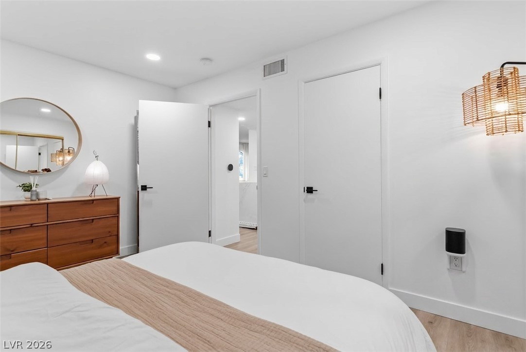 7950 West Flamingo Road, Unit 1180 Las Vegas, NV 89147 - Photo 20 of 26 Recessed lighting illuminates this inviting bedroom, featuring light wood flooring and modern doors.
