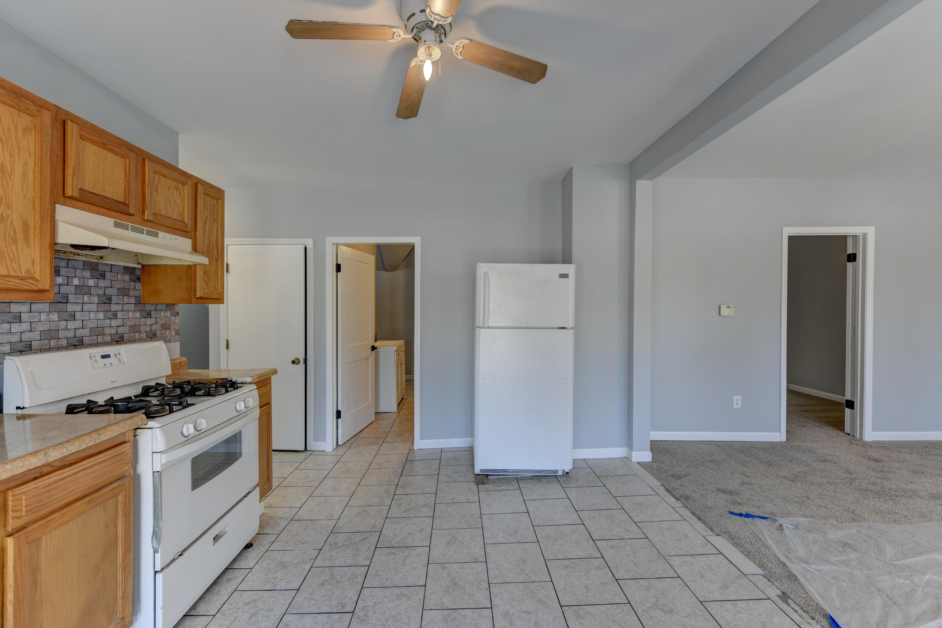 902 Kentucky Street Michigan City, IN 46360 - Photo 11 of 33 a kitchen with a stove a refrigerator and cabinets