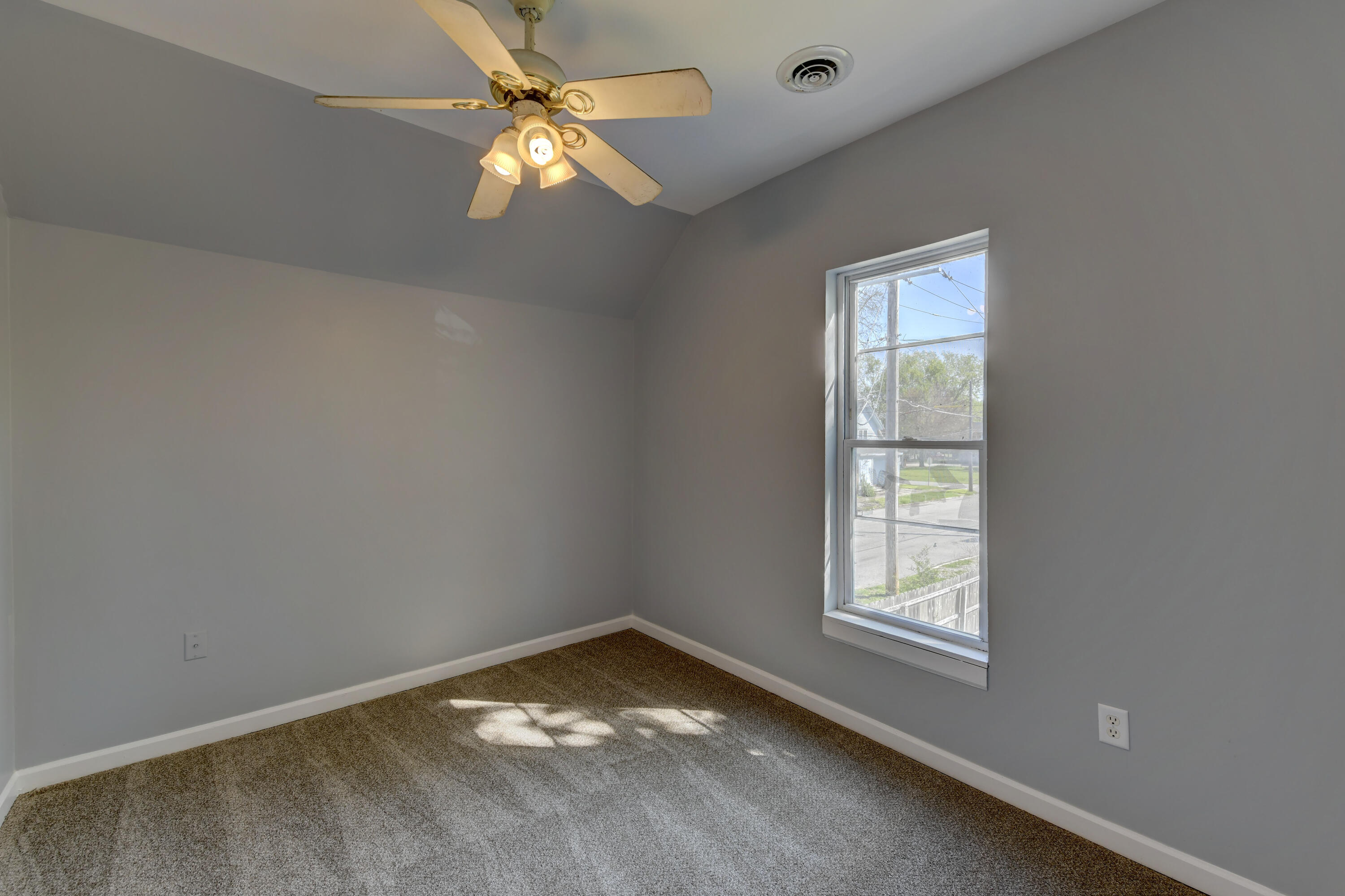 902 Kentucky Street Michigan City, IN 46360 - Photo 13 of 33 an empty room with a window and a fan