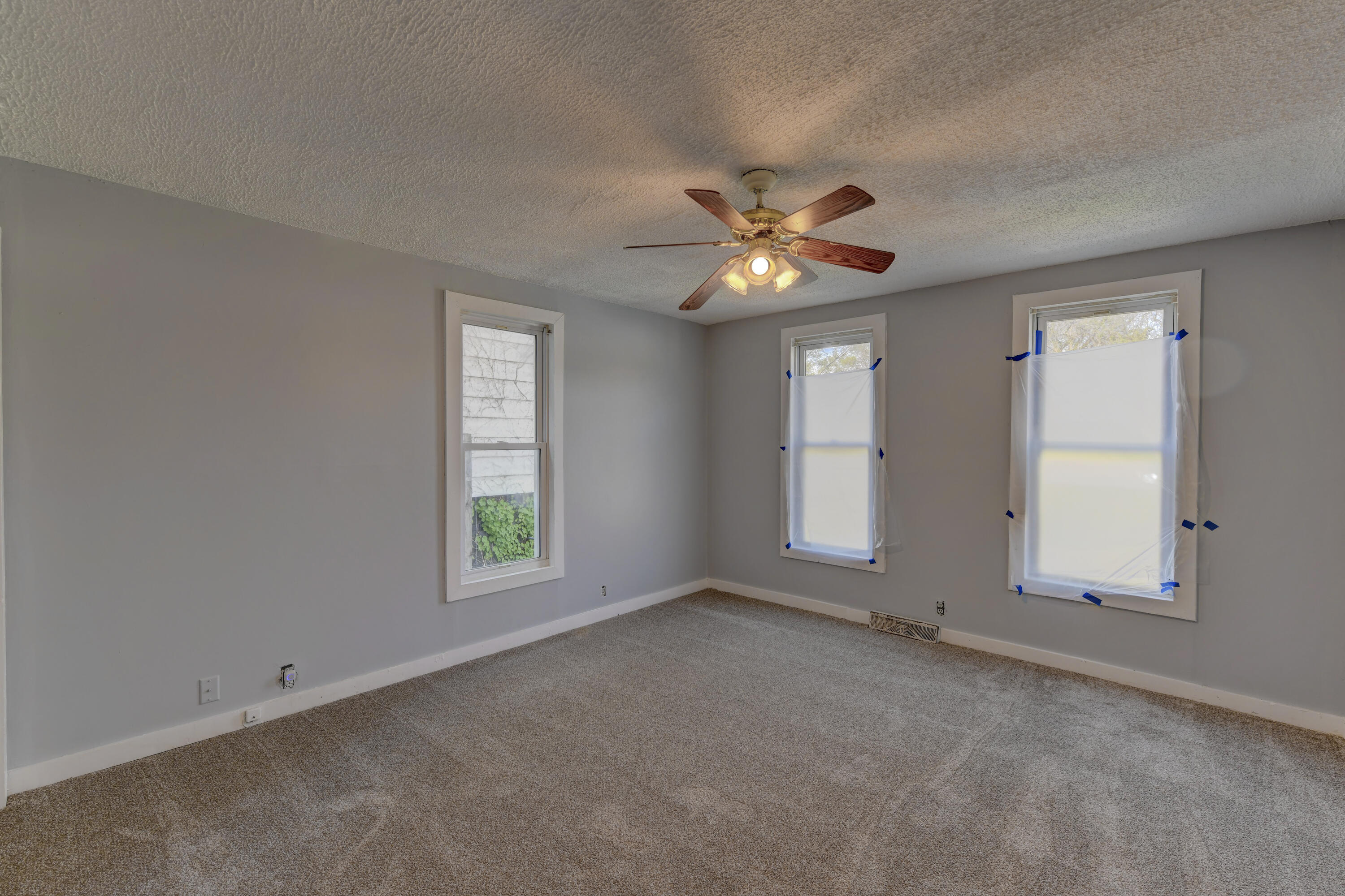 902 Kentucky Street Michigan City, IN 46360 - Photo 15 of 33 an empty room with windows and ceiling fan