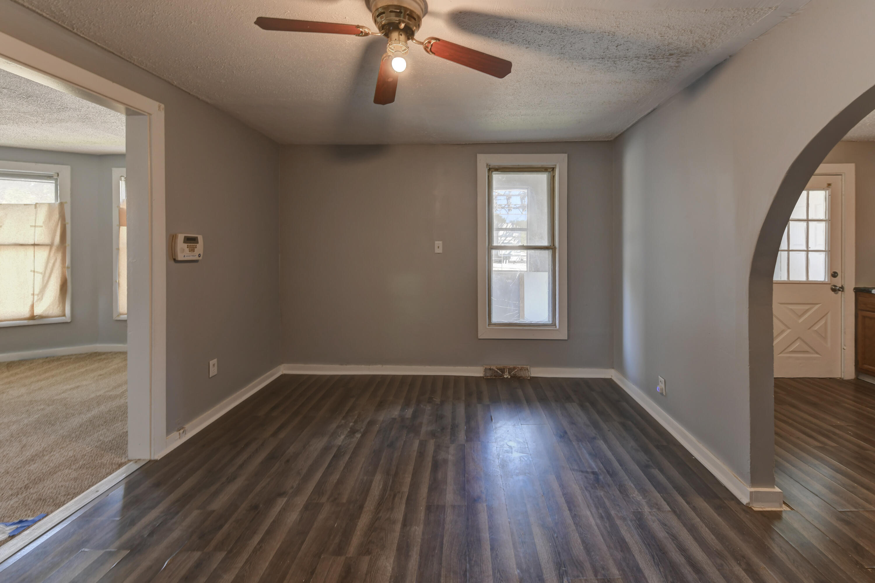 902 Kentucky Street Michigan City, IN 46360 - Photo 23 of 33 an empty room with wooden floor fan and windows