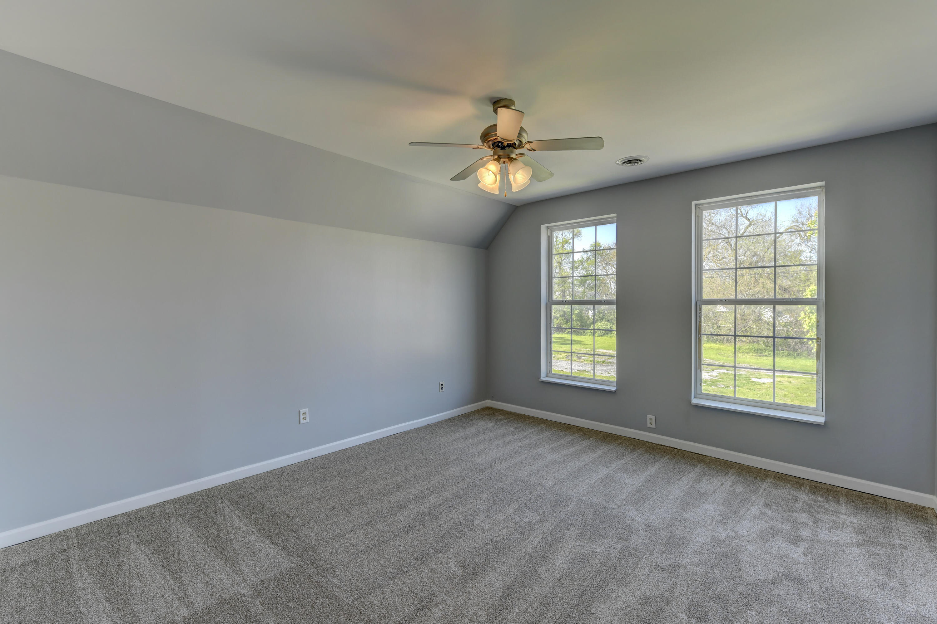 902 Kentucky Street Michigan City, IN 46360 - Photo 6 of 33 an empty room with chandelier fan and windows