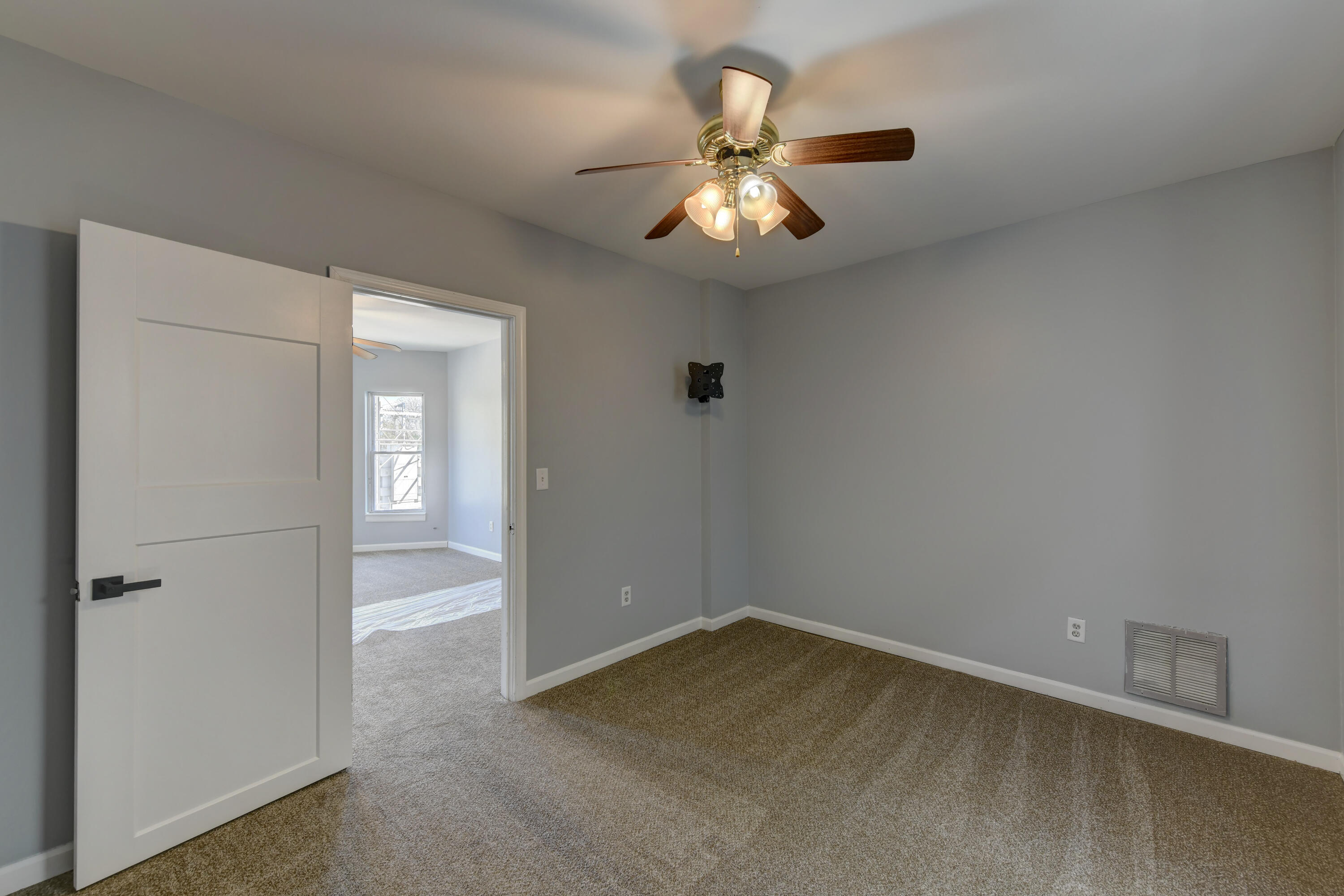 902 Kentucky Street Michigan City, IN 46360 - Photo 9 of 33 en empty room with windows and fan