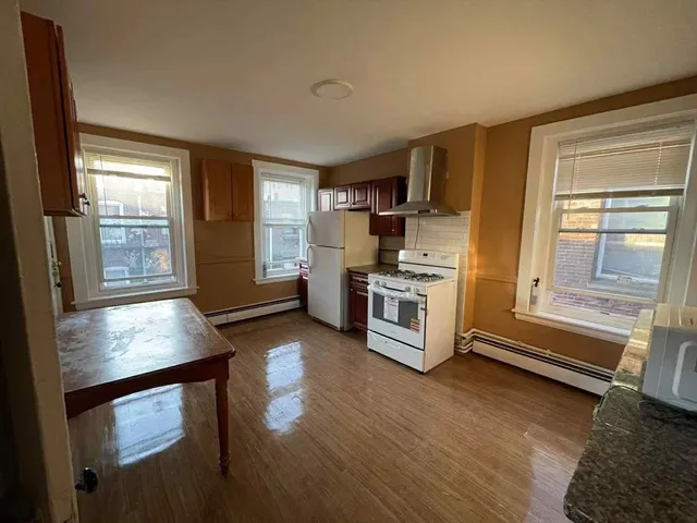 a kitchen with wooden floors and appliances