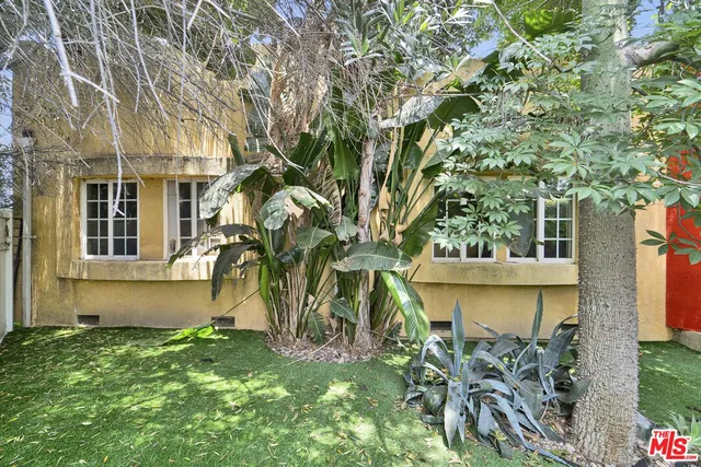 a front view of a house with a yard and tree s