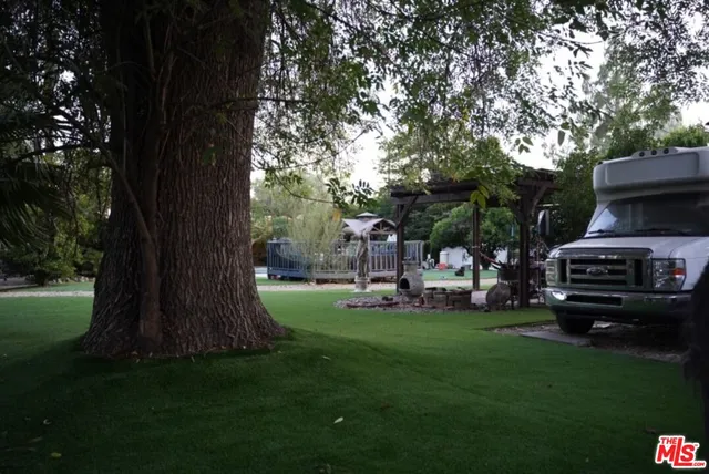 a sign that is sitting in front of a tree