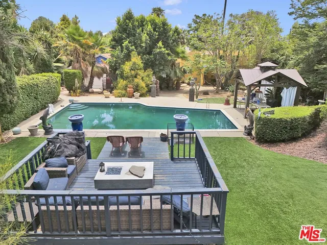 a view of a yard with plants and trees
