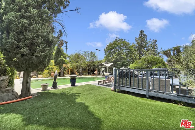 a view of a patio with table and chairs under an umbrella