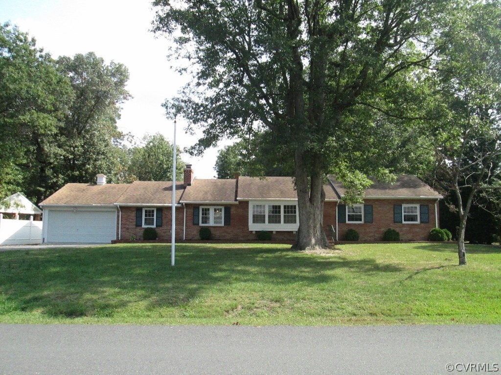 a front view of a house with a garden and trees