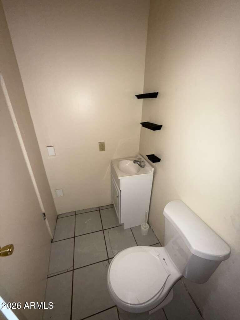 830 East 9th Street, Unit 3 Douglas, AZ 85607 - Photo 13 of 17 a white toilet sitting next to a bathroom sink and a mirror
