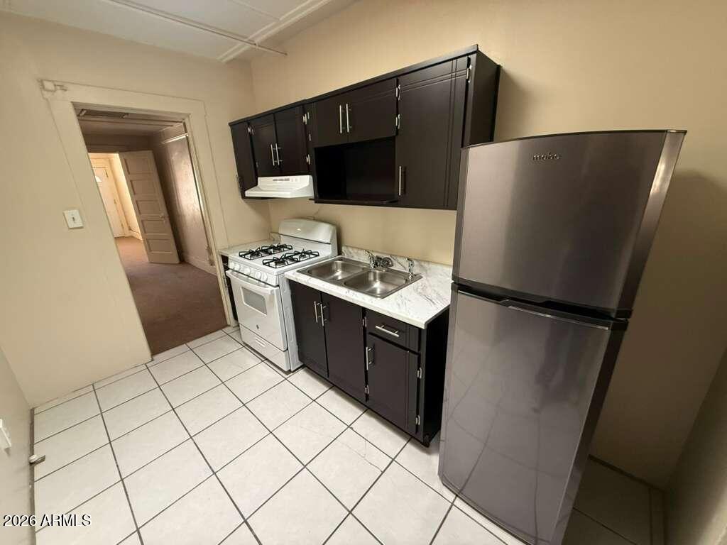 830 East 9th Street, Unit 3 Douglas, AZ 85607 - Photo 10 of 17 a kitchen with stainless steel appliances a refrigerator and a stove top oven
