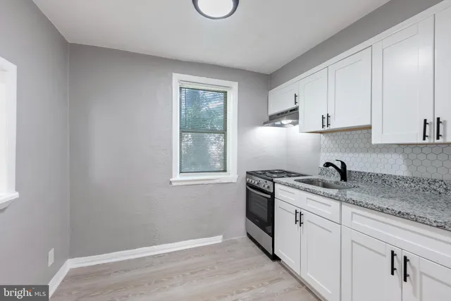 a kitchen with a sink stove and cabinets