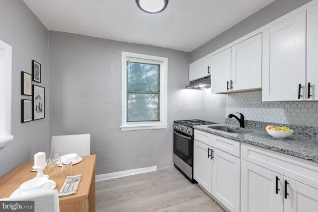 a kitchen with stainless steel appliances granite countertop a sink a stove and a wooden floors