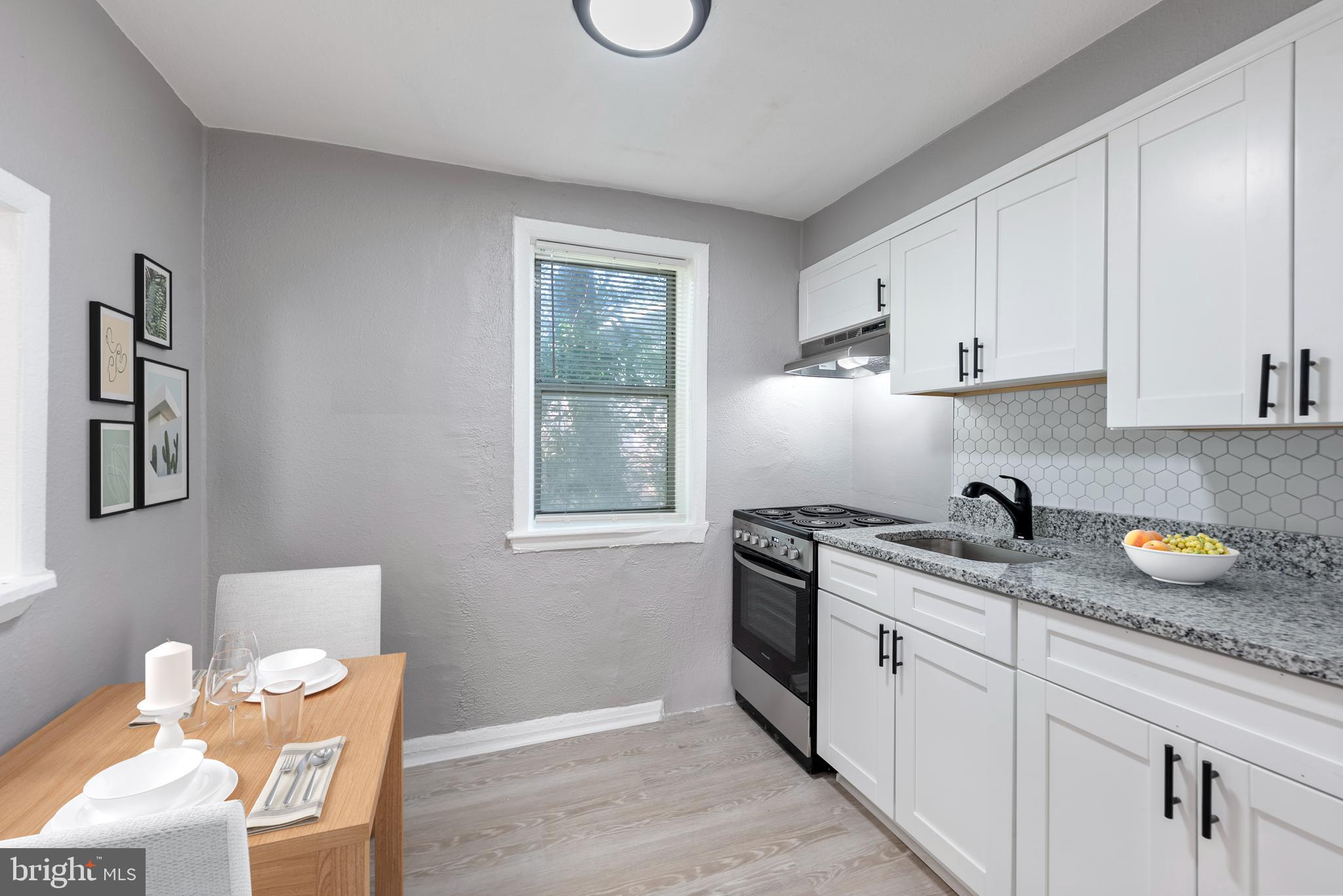 3904 Penhurst Avenue, Unit D Baltimore, MD 21215 - Photo 7 of 11 a kitchen with stainless steel appliances granite countertop a sink a stove and a wooden floors