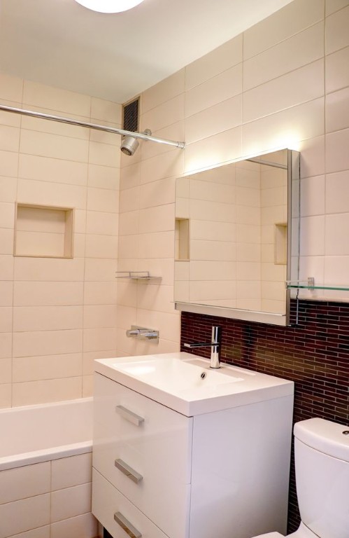 211 East 18th Street, Unit 2P Manhattan, NY 10003 - Photo 4 of 18 a bathroom with a sink a toilet and shower