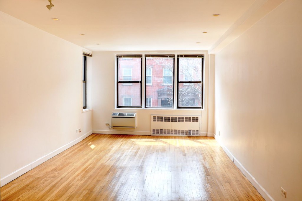 211 East 18th Street, Unit 2P Manhattan, NY 10003 - Photo 5 of 18 an empty room with wooden floor and windows