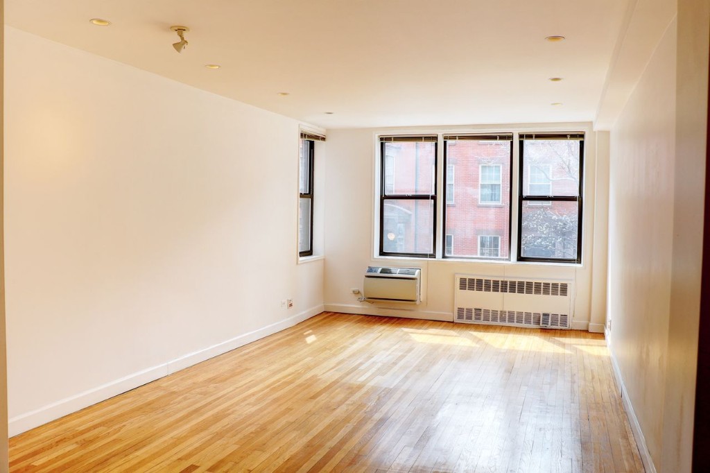 211 East 18th Street, Unit 2P Manhattan, NY 10003 - Photo 6 of 18 an empty room with wooden floor and windows