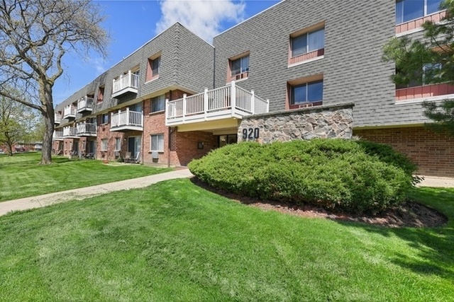 920 Ridge Square, Unit 216 Elk Grove Village, IL 60007 - Photo 1 of 12 a front view of a house with a garden