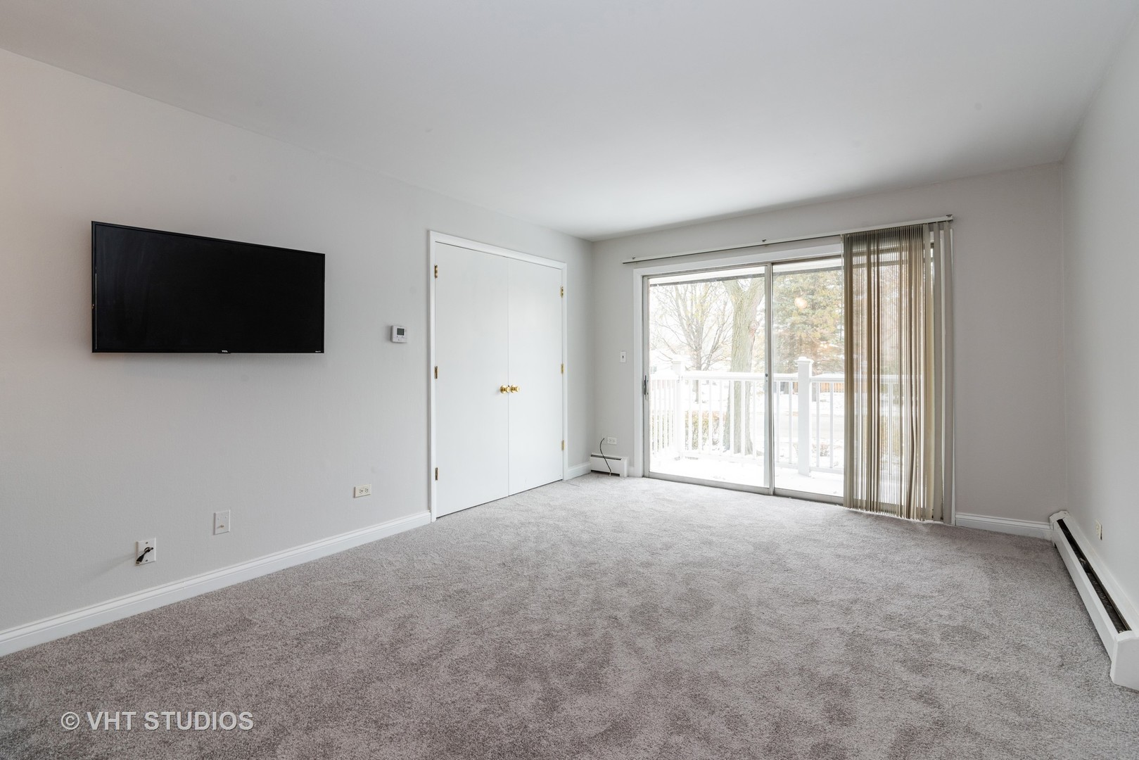 920 Ridge Square, Unit 216 Elk Grove Village, IL 60007 - Photo 5 of 12 a view of an empty room with a flat screen tv and a window