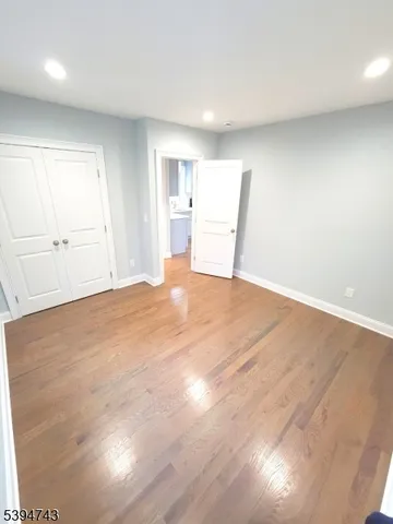 a view of empty room with wooden floor and window