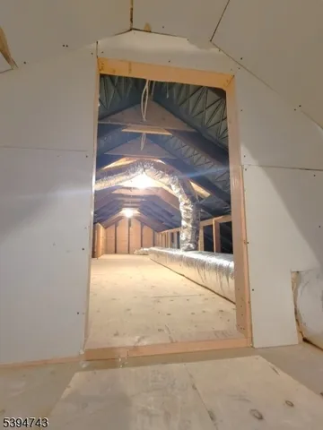 a view of empty room with wooden floor and window