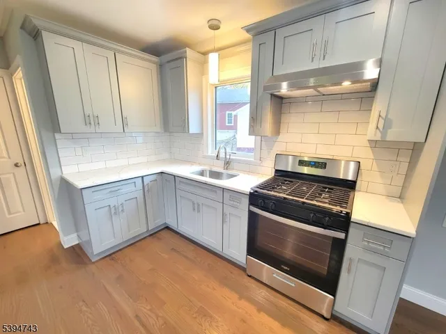a kitchen with a sink stove and cabinets