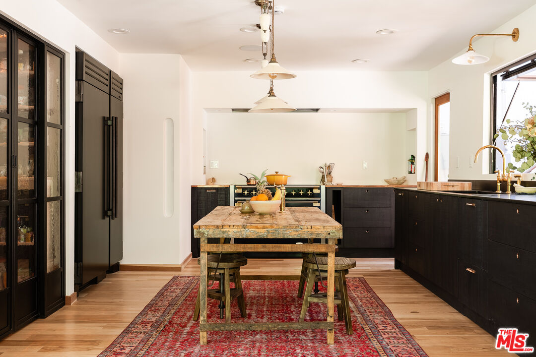 26237 Fairside Road Malibu, CA 90265 - Photo 22 of 34 a dining room with a table chairs and a kitchen view
