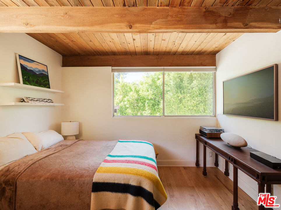26237 Fairside Road Malibu, CA 90265 - Photo 32 of 34 a bedroom with a bed and a flat screen tv