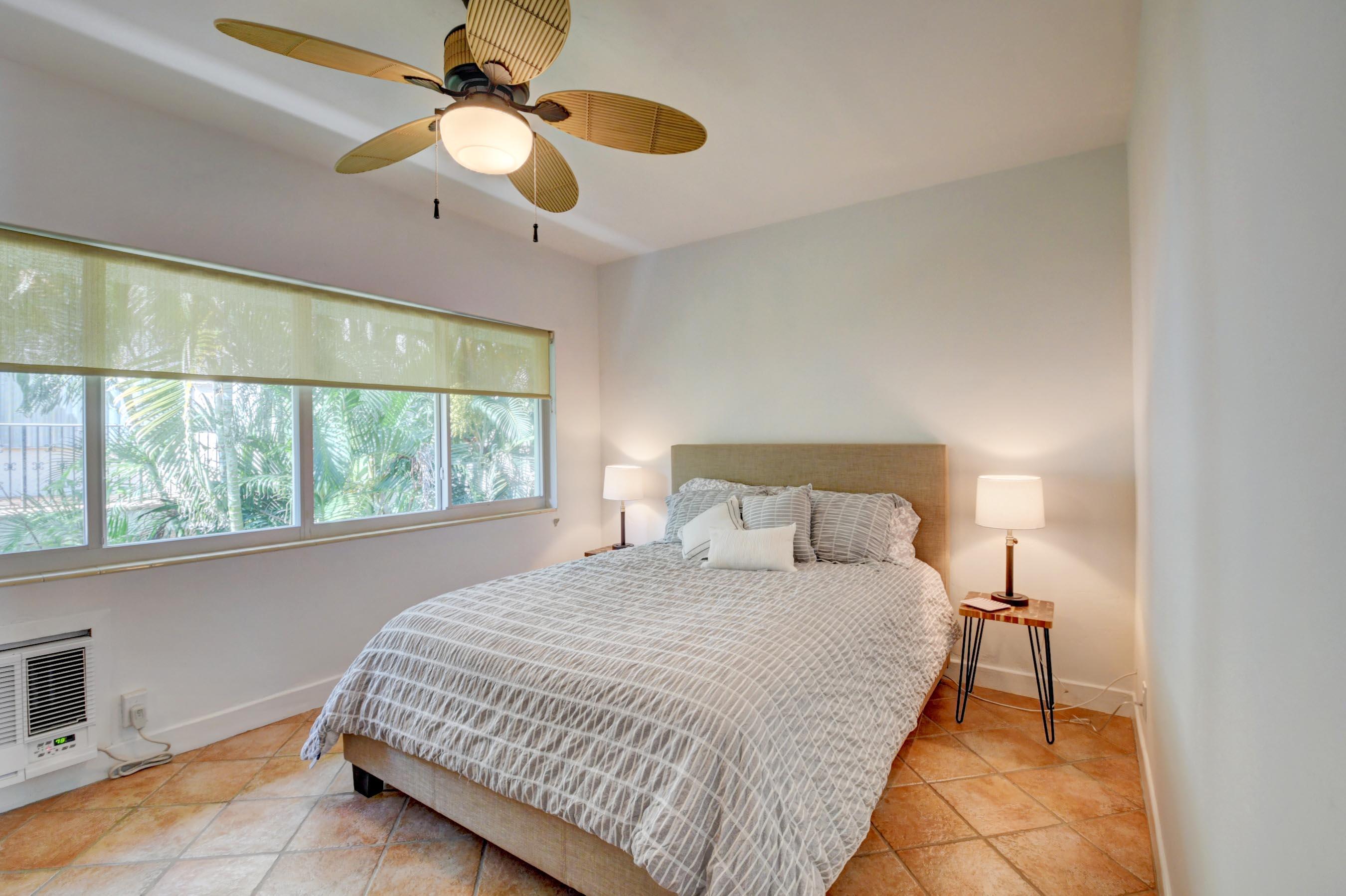 1006 Casuarina Road, Unit 8 Delray Beach, FL 33483 - Photo 13 of 19 a bedroom with a bed and a chandelier