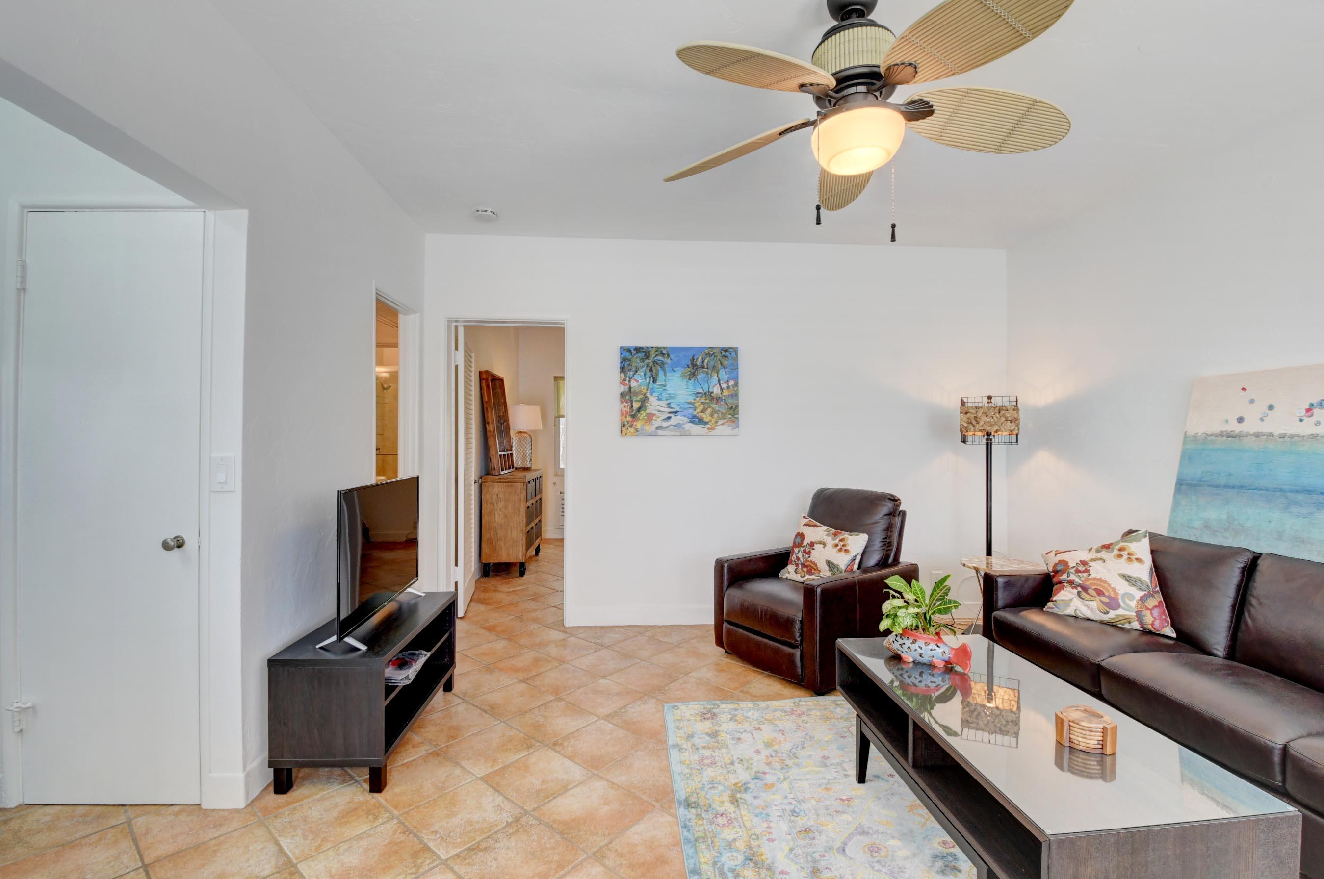 1006 Casuarina Road, Unit 8 Delray Beach, FL 33483 - Photo 4 of 19 a living room with furniture a flat screen tv and a ceiling fan