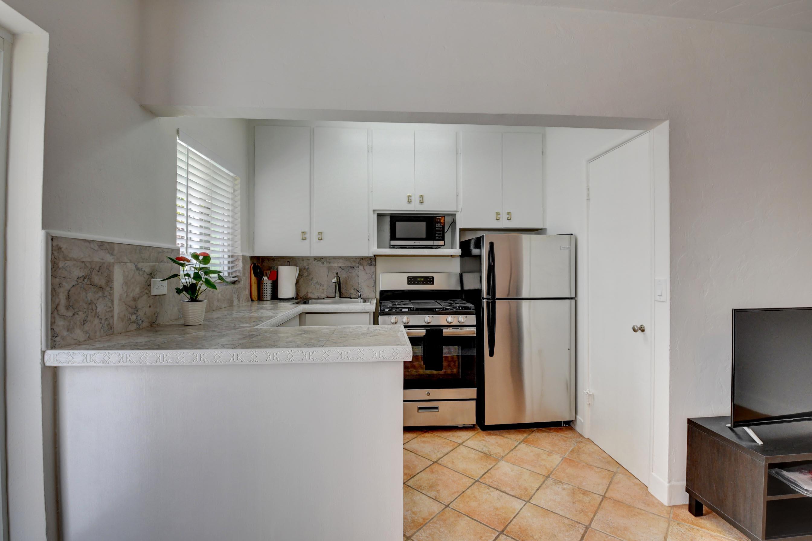 1006 Casuarina Road, Unit 8 Delray Beach, FL 33483 - Photo 5 of 19 a kitchen with stainless steel appliances granite countertop a refrigerator stove top oven a sink and dishwasher