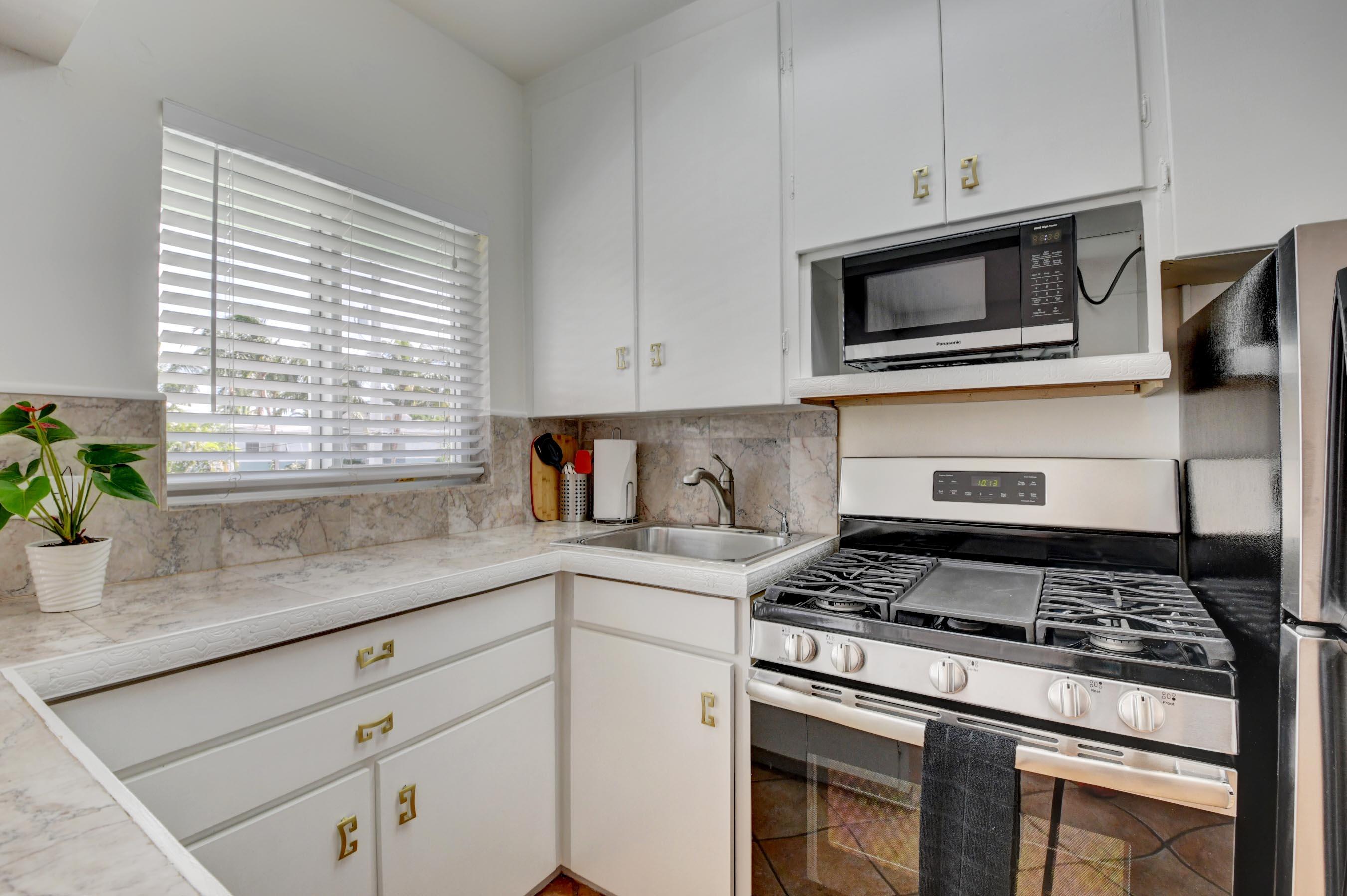 1006 Casuarina Road, Unit 8 Delray Beach, FL 33483 - Photo 7 of 19 a kitchen with granite countertop cabinets stainless steel appliances and a counter space
