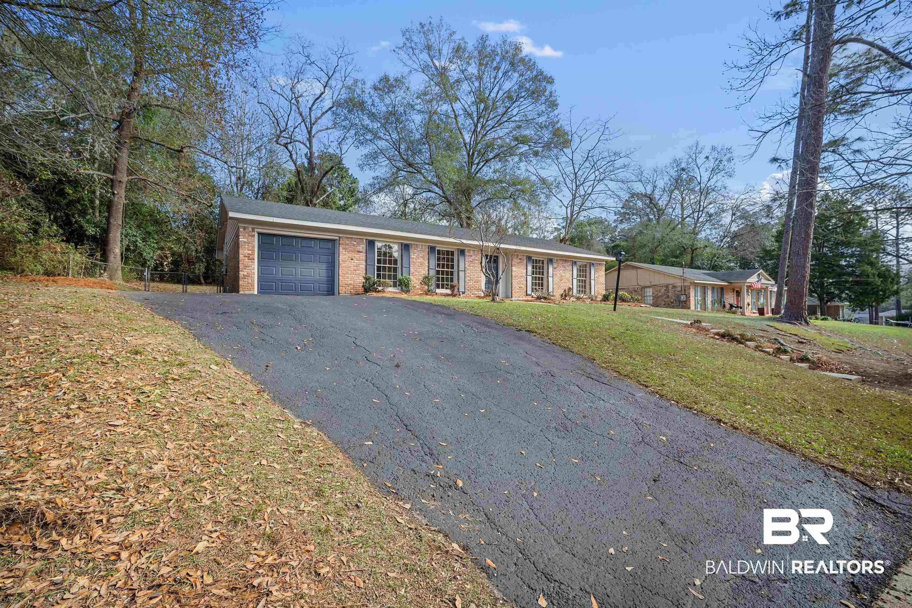 Ranch-style home with asphalt driveway, an attached garage, and brick siding