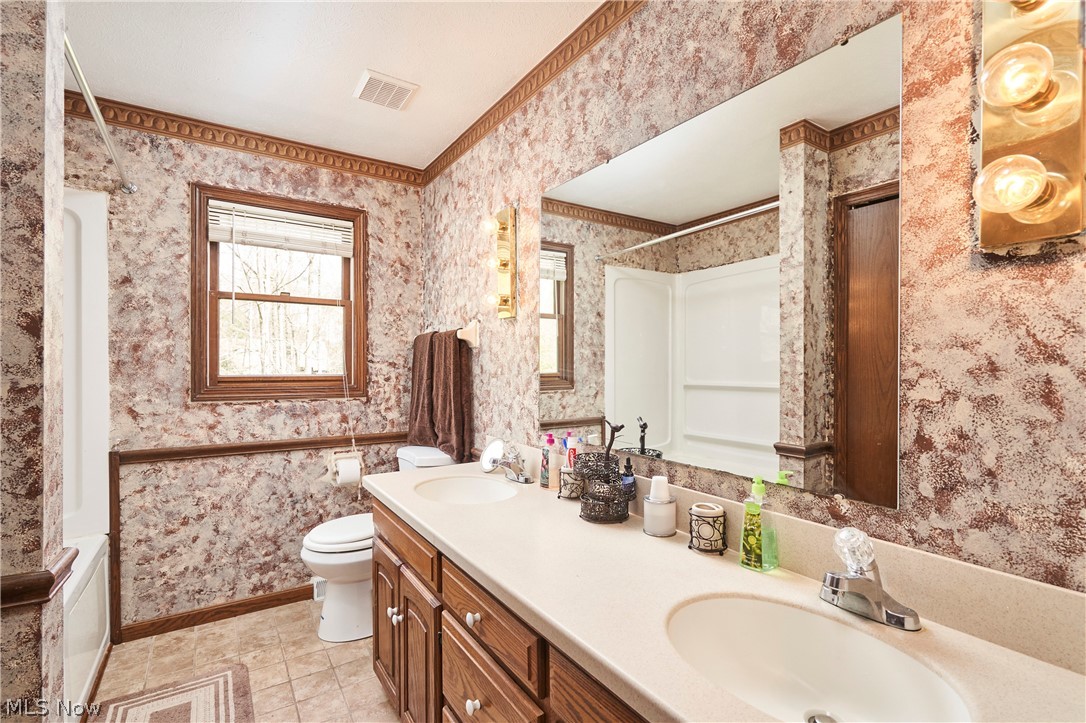 3097 Baughman Road Clinton, OH 44216 - Photo 14 of 27 Full bathroom featuring a double vanity with integrated sinks and a large mirror