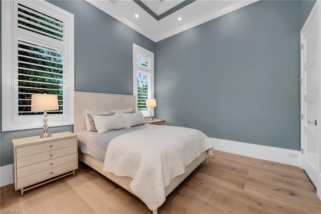 3190 Crayton Road Naples, FL 34103 - Photo 29 of 48 a bedroom with a bed and a night stand