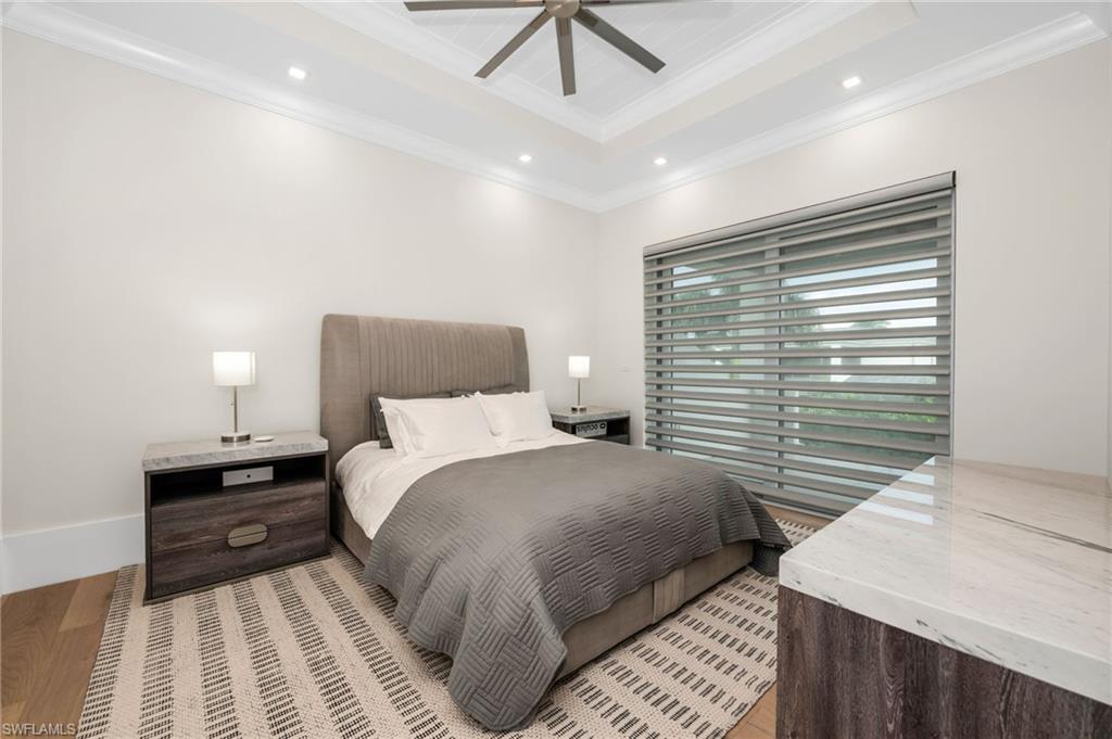 3190 Crayton Road Naples, FL 34103 - Photo 31 of 48 a bedroom with a bed and a chandelier