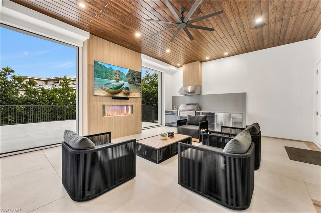 3190 Crayton Road Naples, FL 34103 - Photo 35 of 48 a living room with couches a flat screen tv and next to a window