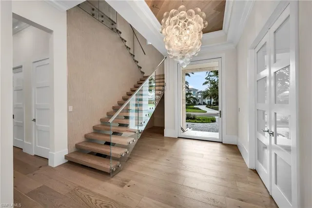 a kitchen with stainless steel appliances kitchen island granite countertop a sink and a wooden floors